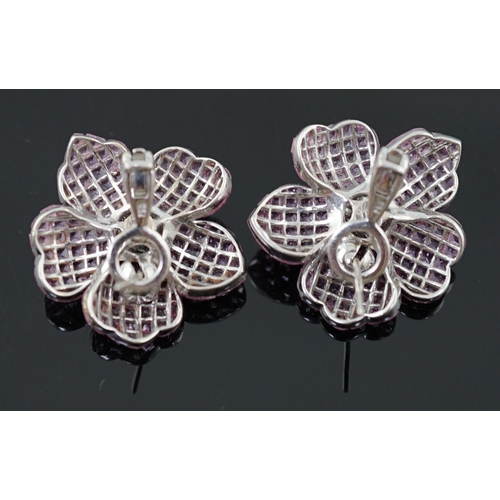 615 - A pair of 18k white gold, pink sapphire and diamond cluster set flower head ear clips/earrings, each... 