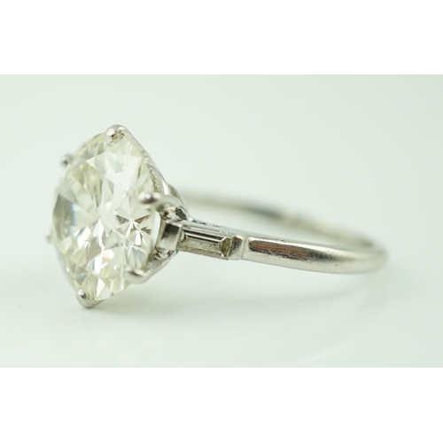 618 - A platinum and single stone diamond set ring, with baguette cut diamond set shoulders, the round cut... 