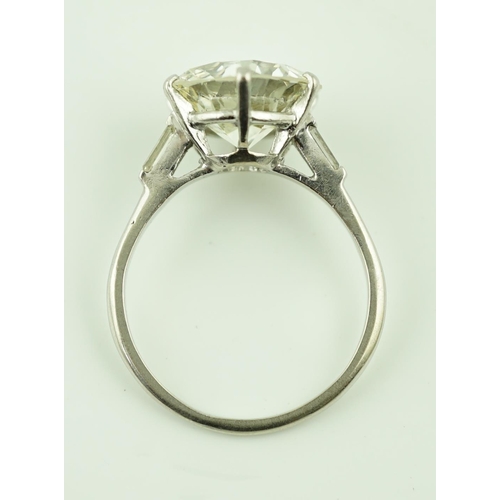 618 - A platinum and single stone diamond set ring, with baguette cut diamond set shoulders, the round cut... 