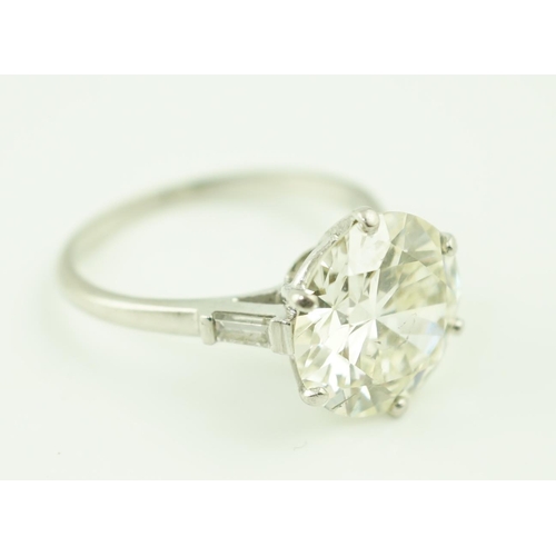 618 - A platinum and single stone diamond set ring, with baguette cut diamond set shoulders, the round cut... 