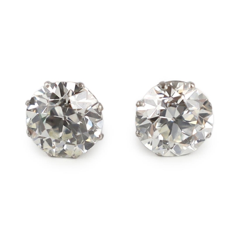 624 - A pair of early 20th century platinum and claw set diamond ear studs, the Old European cut stones wi... 