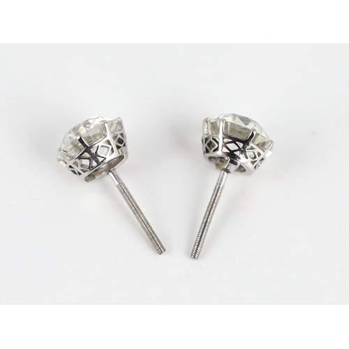 624 - A pair of early 20th century platinum and claw set diamond ear studs, the Old European cut stones wi... 