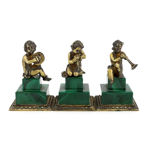 74 - A set of three Italian silver gilt figures of musical putti, each seated upon a stepped malachite ba... 