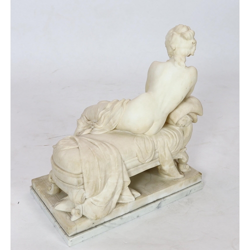 90 - An early 20th century French carved white marble figure of a semi-clad woman seated upon a daybed, r... 