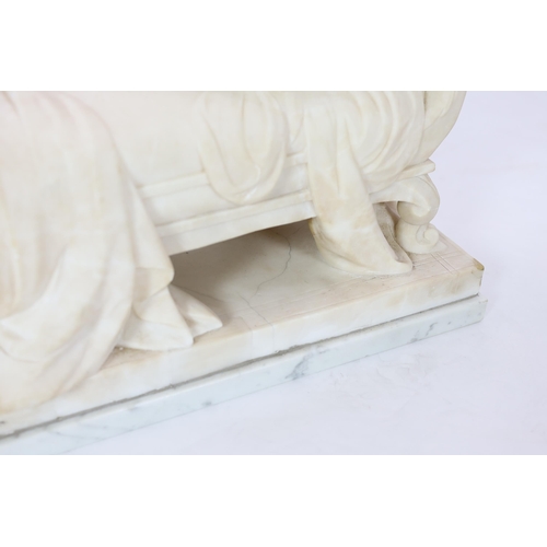 90 - An early 20th century French carved white marble figure of a semi-clad woman seated upon a daybed, r... 