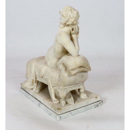 90 - An early 20th century French carved white marble figure of a semi-clad woman seated upon a daybed, r... 