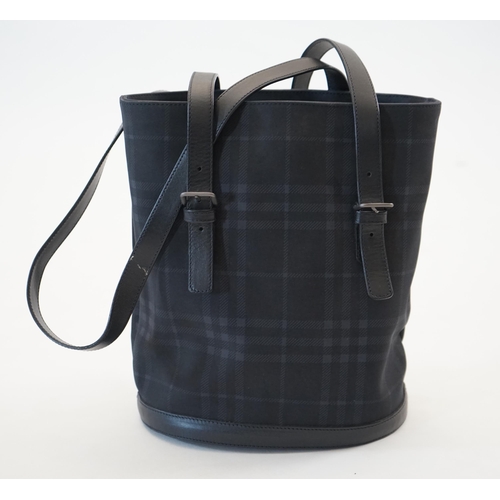 1004 - A Burberry bucket bag in blue black tartan canvas and leather, pewter coloured metalware, with dust ... 