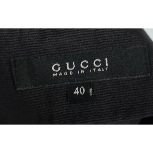 1016 - A pair of Gucci lady's textured satin trousers with gold tone diamante snaffle detail to the back an... 