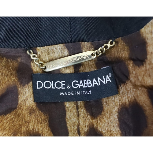 1030 - A lady's Dolce & Gabbana gold metallic leather jacket, with black lapels and leopard print lining, s... 