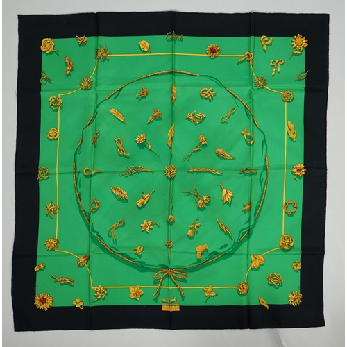 1044 - A Hermès 'Clips' 1986 Vladimir Rybaltchenko silk scarf, in vibrant green and gold with navy blue bor... 