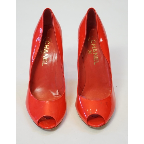 1057 - A pair of Chanel lady's metallic coral peep toe patent leather heels, with gold tone CC detail to th... 