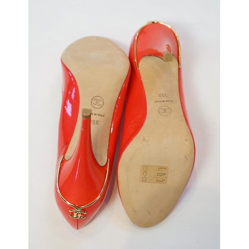 1057 - A pair of Chanel lady's metallic coral peep toe patent leather heels, with gold tone CC detail to th... 