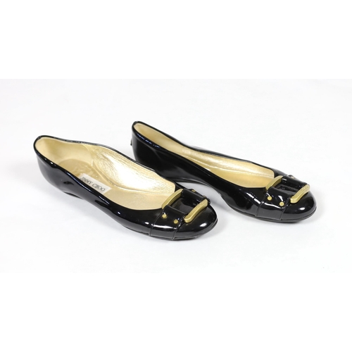 1071 - A pair of Jimmy Choo lady's black patent leather pumps with gold buckle, with rubber sole and dust b... 