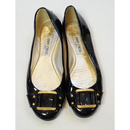 1071 - A pair of Jimmy Choo lady's black patent leather pumps with gold buckle, with rubber sole and dust b... 