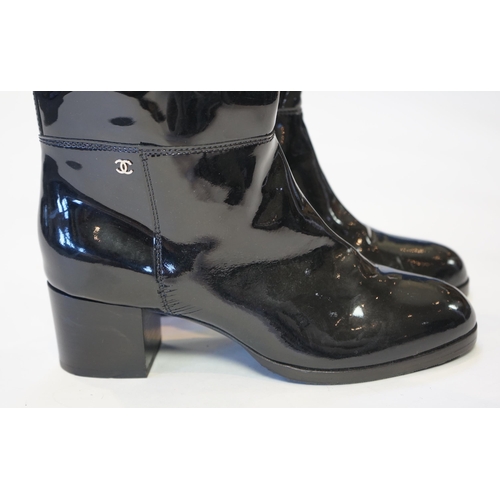 1075 - A pair of Chanel lady's black patent knee high mid heel rain boots, with CC to the outside ankle are... 