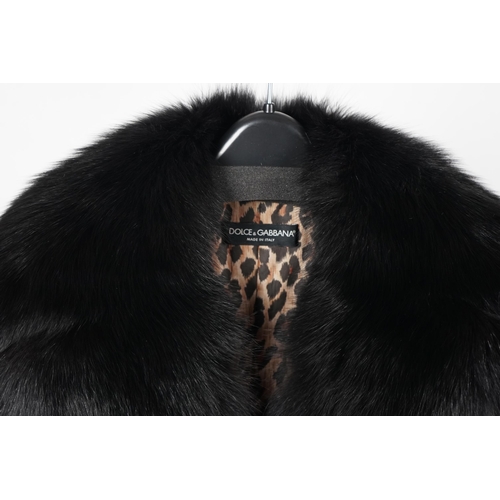 1113 - A Dolce & Gabbana lady's black wool coat with detachable fur collar, leopard print lining and tie be... 