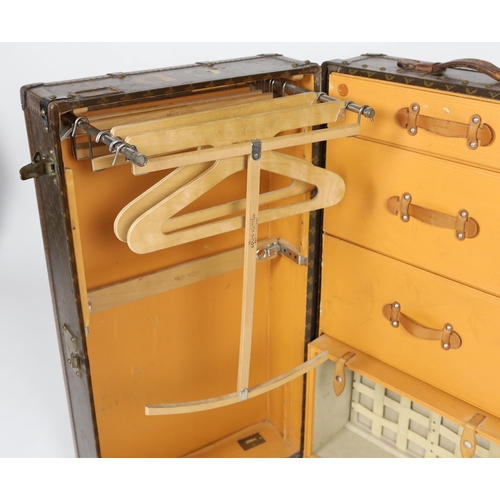 1150 - A vintage Louis Vuitton monogram canvas wardrobe trunk, with iron and brass mounts, and brass studde... 