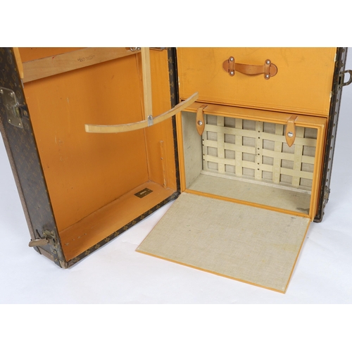 1150 - A vintage Louis Vuitton monogram canvas wardrobe trunk, with iron and brass mounts, and brass studde... 