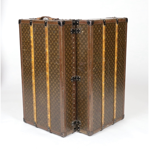 1150 - A vintage Louis Vuitton monogram canvas wardrobe trunk, with iron and brass mounts, and brass studde... 