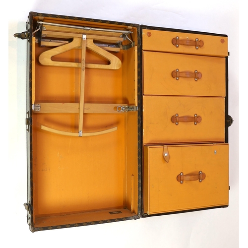 1150 - A vintage Louis Vuitton monogram canvas wardrobe trunk, with iron and brass mounts, and brass studde... 