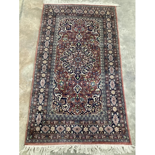 1215 - A North West Persian mauve ground multi-bordered rug, 165 x 94cm