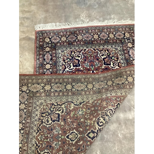 1215 - A North West Persian mauve ground multi-bordered rug, 165 x 94cm