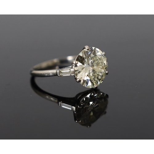 618 - A platinum and single stone diamond set ring, with baguette cut diamond set shoulders, the round cut... 