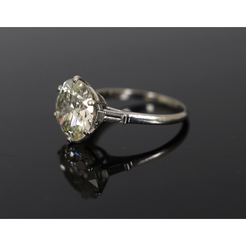 618 - A platinum and single stone diamond set ring, with baguette cut diamond set shoulders, the round cut... 