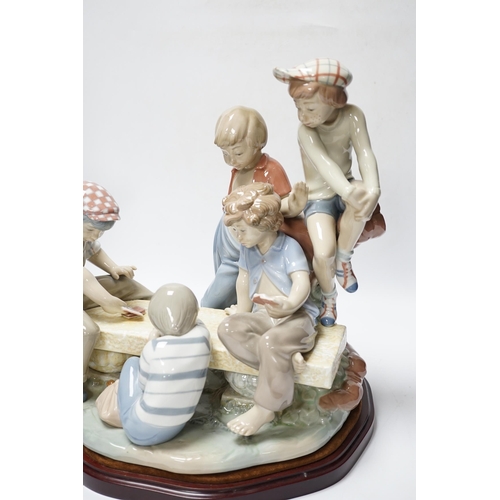 448 - A large Nao figure group on stand of five boys sitting around a table playing cards, 33cm