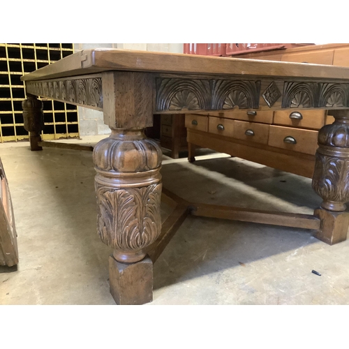 121 - A very large 17th century style oak refectory dining table, with cleated three plank top on carved b... 