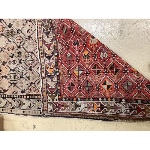 1129 - An antique Turkish faded red ground rug, 158 x 98cm