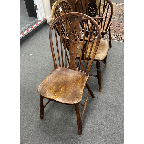 1170 - A set of three mid 19th century elm and ash wheel back dining chairs, one with arms