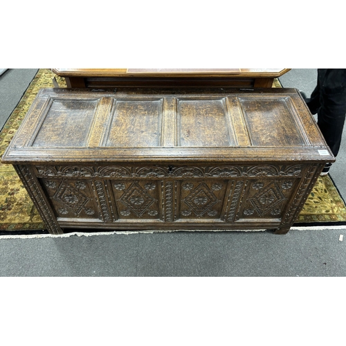 1174 - A late 17th century carved oak coffer, the front with four lozenge and rosette panels, beneath a lun... 