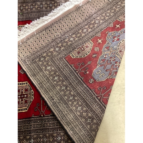 1197 - A Pakistan red ground triple medallion rug 200cm x 126cm.