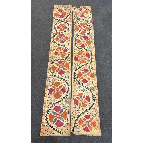 1335 - A pair of Uzbekistan long wide panels, both embroidered in mostly red, coral and blue with large sym... 