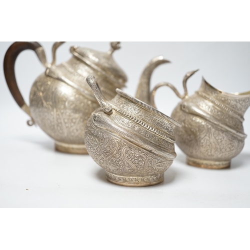 852 - A 20th century Indian three piece embossed white metal tea set, with boteh and cobra decoration, gro... 