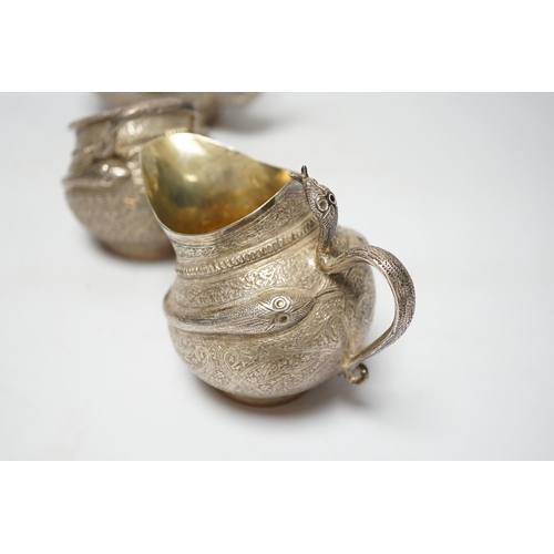 852 - A 20th century Indian three piece embossed white metal tea set, with boteh and cobra decoration, gro... 