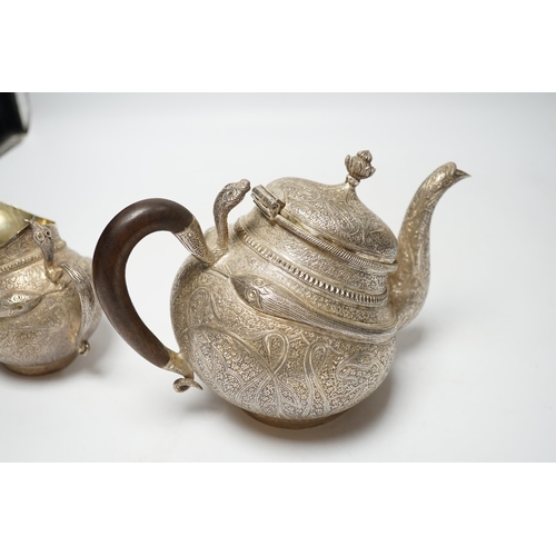 852 - A 20th century Indian three piece embossed white metal tea set, with boteh and cobra decoration, gro... 