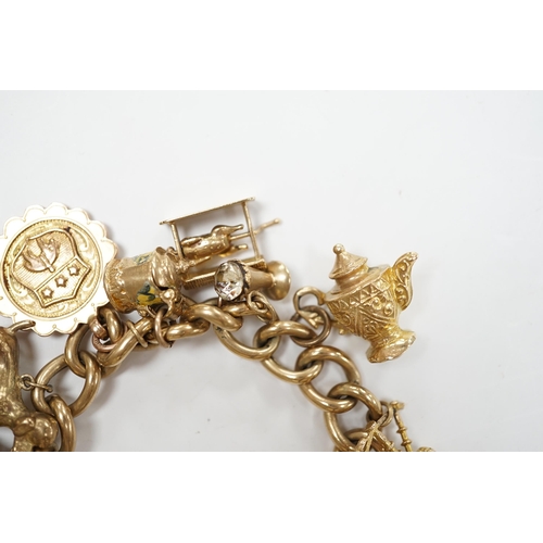 902 - An early 1960's 9ct gold curb link charm bracelet, hung with fifteen assorted charms, including twel... 