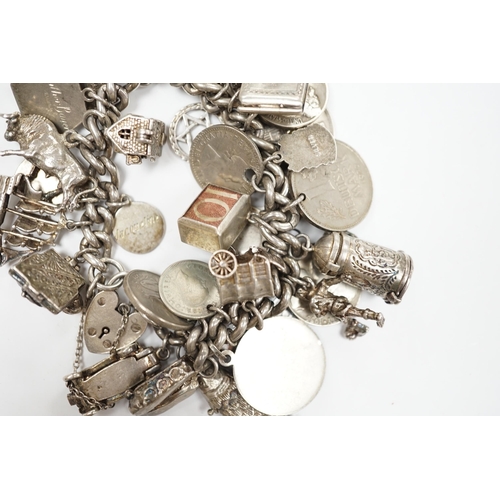 906 - A silver charm bracelet, hung with assorted mainly white metal charms including tankard and Knight's... 