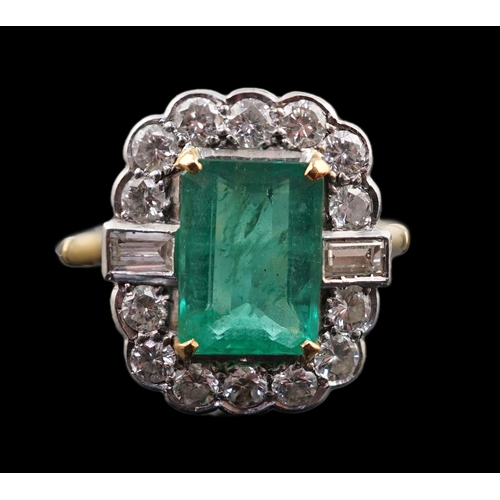 909 - An Art Deco style gold, emerald and diamond set oval cluster ring, the central emerald measuring app... 