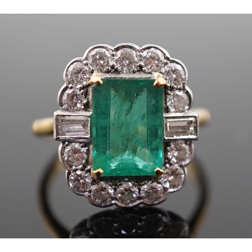 909 - An Art Deco style gold, emerald and diamond set oval cluster ring, the central emerald measuring app... 