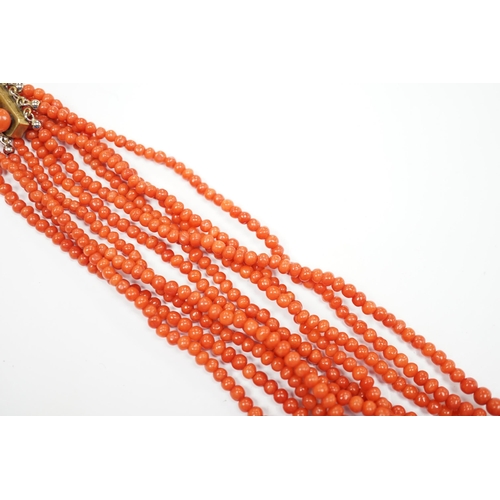 1886 - A five strand coral bead choker necklace, with coral set yellow metal clasp, approx. 44cm.