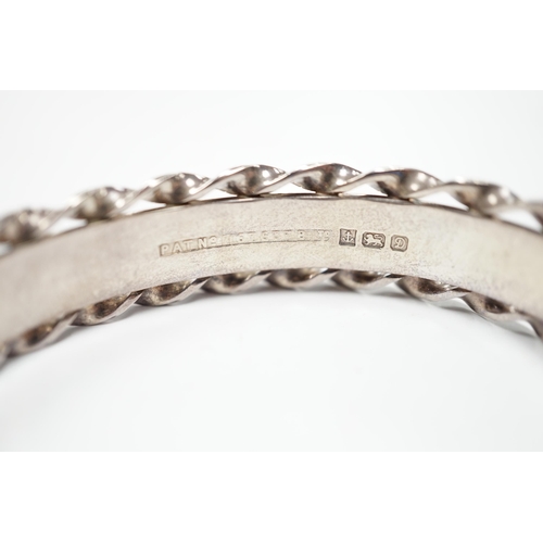 1889 - An Elizabeth II bright cut engraved silver hinged bangle, with spiral borders, Birmingham, 1978.... 