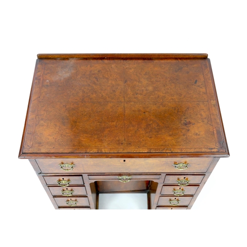 132 - An early 18th century walnut kneehole secretaire desk, with quarter veneered top and fall front draw... 