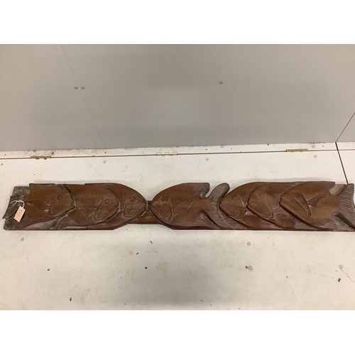 17 - A carved wood panel of piranha fish, length 166cm