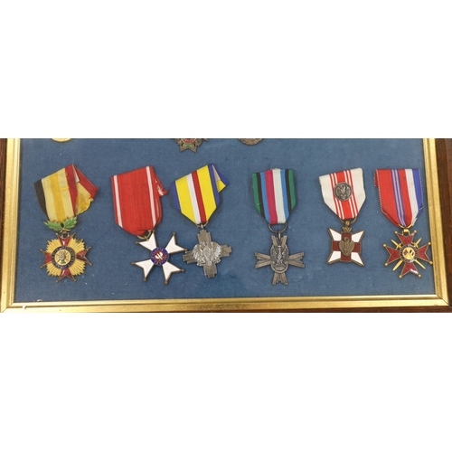 274 - Twenty-seven medals and awards mounted in oak frames, including; French 1939-45 War Medal, Poland Le... 