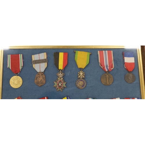 274 - Twenty-seven medals and awards mounted in oak frames, including; French 1939-45 War Medal, Poland Le... 