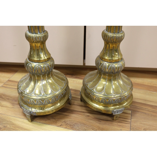 392 - A pair of tall 19th century repoussé brass pricket altar sticks, 76cm high