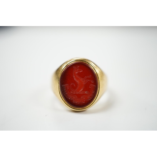 905 - An 18ct and oval intaglio carnelian set signet ring, carved with family crest and motto, size K, gro... 